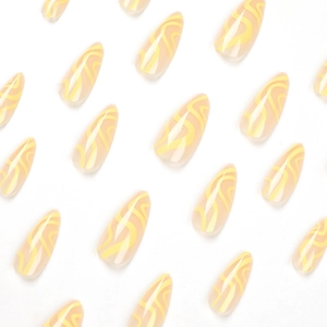 Glossy almond press-on nails with yellow wave patterns and translucent beige base