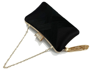 Macro detail of black satin woven clutch with golden tassel and sparkling diamond buckle