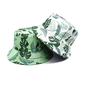 Unisex tropical leaf print bucket hats in green and white botanic patterns for sun protection