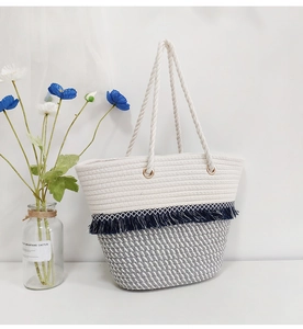 Detail of woven cotton tote bag featuring tassels and dual-tone bohemian fringe design