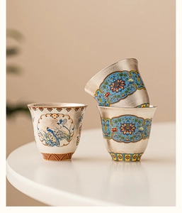 Detailed close-up of three handcrafted cloisonné enamel teacups with traditional patterns
