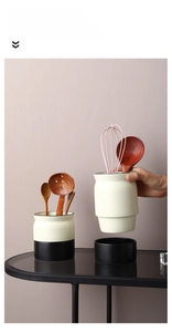 Detail of the split-design ceramic kitchen utensil holder with a cream matte finish