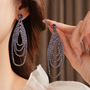 Detail of purple rhinestone tassel earrings showing long cascading layered crystals