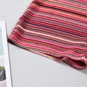 Macro view of striped crochet knit fabric showing detailed mesh stitches and wavy edge