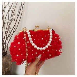 Détail du sac de soirée à roses rouges avec chaîne en perles et fermoir doré