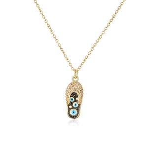 Detail eines 18K vergoldeten Flip-Flop-Anhängers mit Zirkonia und blauen Evil Eye-Mustern