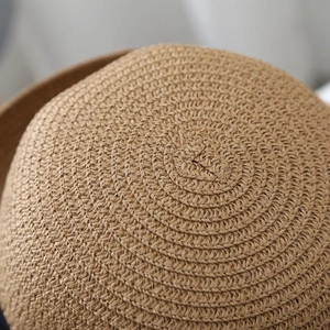 Close-up of tightly woven natural straw texture and fine spiral craftsmanship on a summer hat