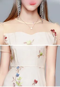 Detailed embroidery of colorful floral patterns on a high-waisted beige dress for women