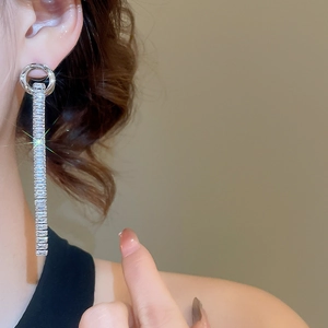 Close-up of silver long tassel earrings featuring baguette-cut cubic zirconia crystals