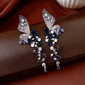 Detailed macro of vintage butterfly drop earrings with blue crystal tassel fringes