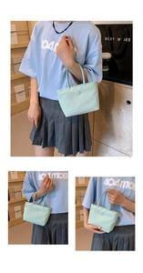 Détail du sac seau en nylon vert clair avec patch de lettre rond et doubles poignées