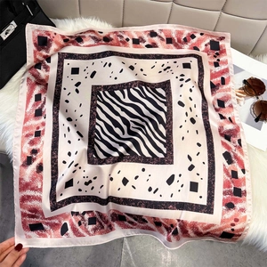 Detail of a square silk scarf with zebra stripes and geometric patterns on white fur