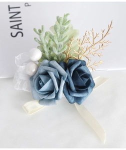 Detailed shot of dusty blue artificial rose boutonniere with golden leaves and pearls