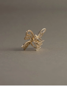 Detailed close-up of a golden hollow butterfly hair claw clip with intricate wing patterns