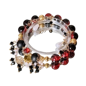 Multi-layer beaded bracelet with red gems and black gradient glass beads on display