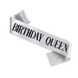 Silver satin Birthday Queen sash with bold black lettering and a golden safety pin