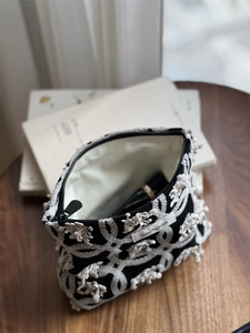Detail view of cotton linen makeup bag with white butterfly embroidery and zipper