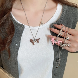 Close-up of cute dachshund pendant necklaces with zircon bows and faux pearl accents