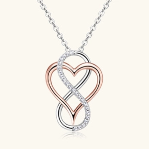 Macro shot of silver and rose gold heart infinity pendant with micro-inlaid zircons