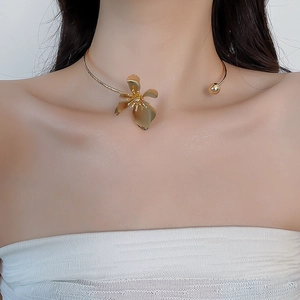 Close-up of golden metallic flower choker with an open design worn on a model's neck