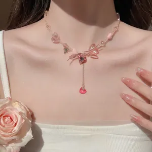 Pink beaded heart bow necklace with crystal pendant shown on model neck for women
