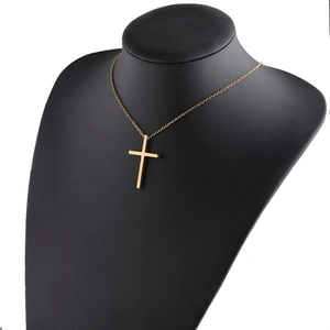 Detailed view of a polished gold stainless steel cross pendant on a fine link chain