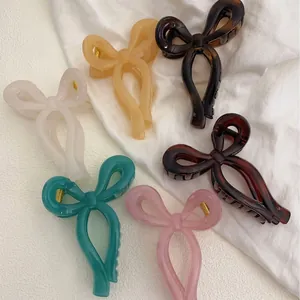 Elegant ribbon bow shark hair clips in six assorted colors on a minimalist white backdrop