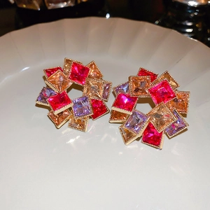 Détails de boucles d'oreilles florales géométriques aux cristaux colorés et bords dorés