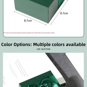 Close-up of a dark green textured jewelry gift box with a satin bow and dimensions