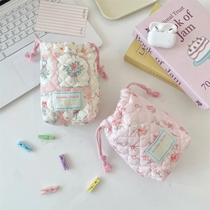 Close-up of quilted floral drawstring camera pouches with cute rabbit patterns on cotton fabric