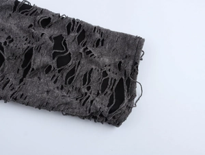 Gros plan de manches en tricot gris foncé avec détails déchirés et doublure noire