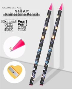 Detail view of 2 nail dotting wax pencils and yellow heart sharpener for rhinestone art