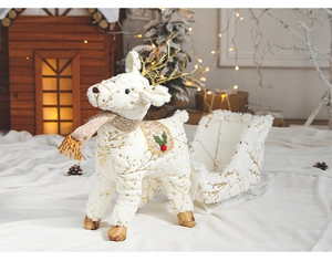 Close-up of white and gold reindeer figurine with sequin scarf and sleigh holiday decor