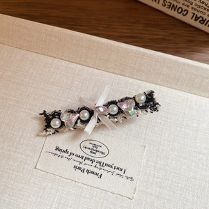 Close-up of a French vintage hair clip with pearls, crystal hearts, and a lace bow