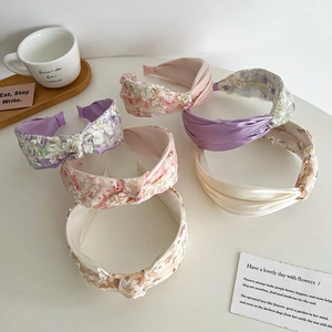 Flat lay of multiple floral lace and satin knot headbands in soft pastel colors