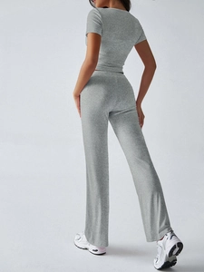 Vista posteriore di un set grigio Y2K a due pezzi con t-shirt e pantaloni larghi