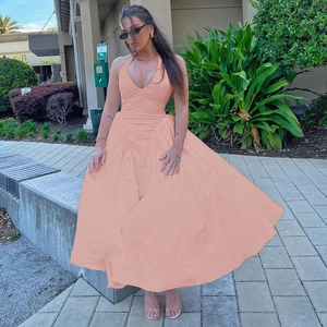 Detailansicht des rosa-orangefarbenen Halter-Maxikleids mit tiefem V-Ausschnitt und Rock