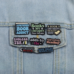 Macro shot of assorted colorful metal enamel book badges on a blue denim jacket pocket