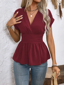 Detail of V-neckline and pleated waist on wine red slim-fit short sleeve top