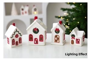 Detailed view of four ceramic Christmas snow house candle holders with red and green accents