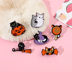 Set of six Halloween enamel pins featuring black cats, pumpkins, and witch hats on pink surface