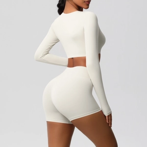Close-up of off-white high-waisted yoga shorts and cropped long sleeve top with slim fit