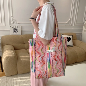 Détail d'un sac cabas en toile à rayures colorées avec étiquette tissée en tissu