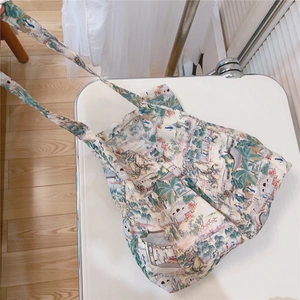 Detail of artistic canvas tote bag with traditional Chinese landscape print on a white chair