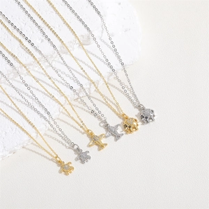 Detail shot of cute elephant, plane, and turtle zircon necklaces in gold and silver