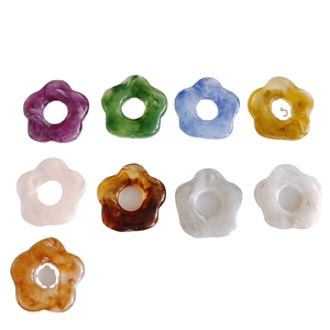 Flat lay of 26mm colorful floral resin charms with marble and tortoiseshell patterns