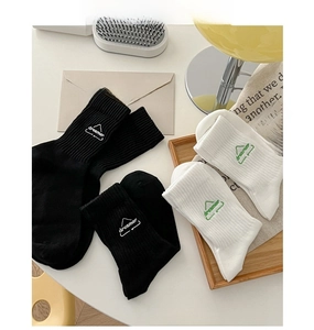 Detail of ribbed cuffs and dreamer letter embroidery on black and white cotton socks