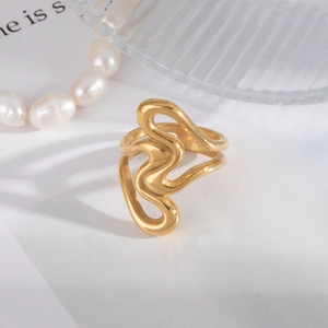 Gros plan détaillé d'une bague dorée ondulée polie sur un fond esthétique de luxe