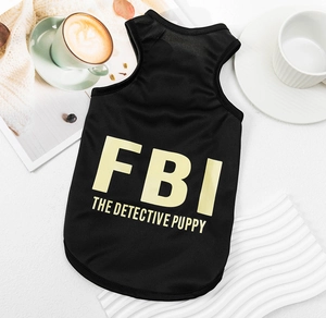 Close-up of black FBI printed pet vest with yellow lettering on textured background