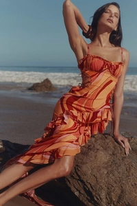 Detail of ruffle hem dress with side lace-up eyelets and vibrant wave pattern print
